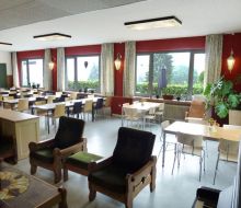 heller Speisesaal mit vielen Tischen und Stuehlen im Das orange Schaf in Willlingen-Usseln