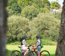 Zwei Radfahrer auf dem Diemelradweg bei Trendelburg, im Hintergrund die Burg