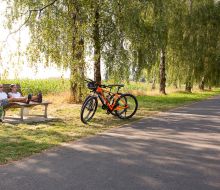 Radler pausieren auf Liegebank bei Trendelburg